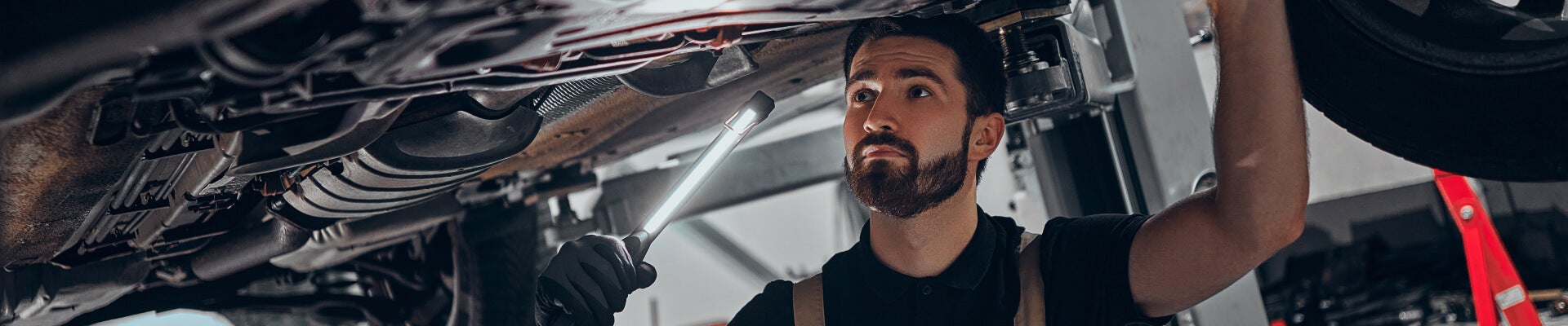 CDJR service worker working under a vehicle