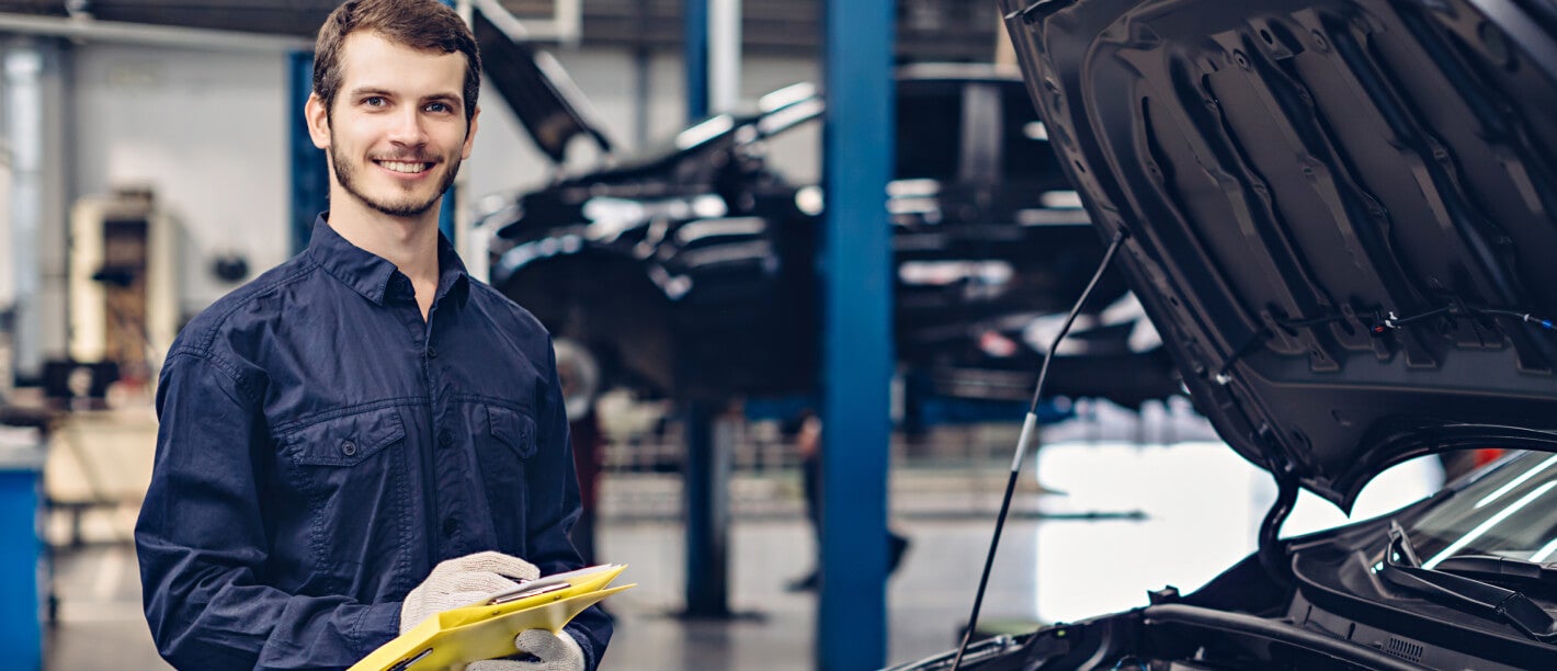 CDJR service working doing an inspection of the engine bay