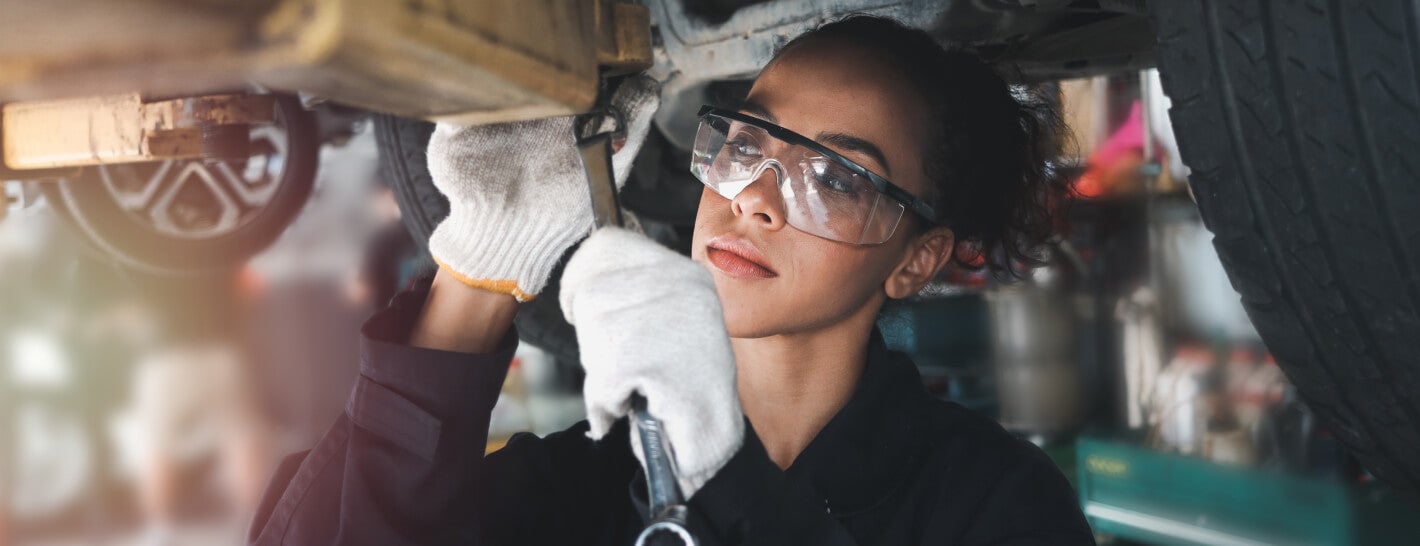 CDJR service worker working under a car