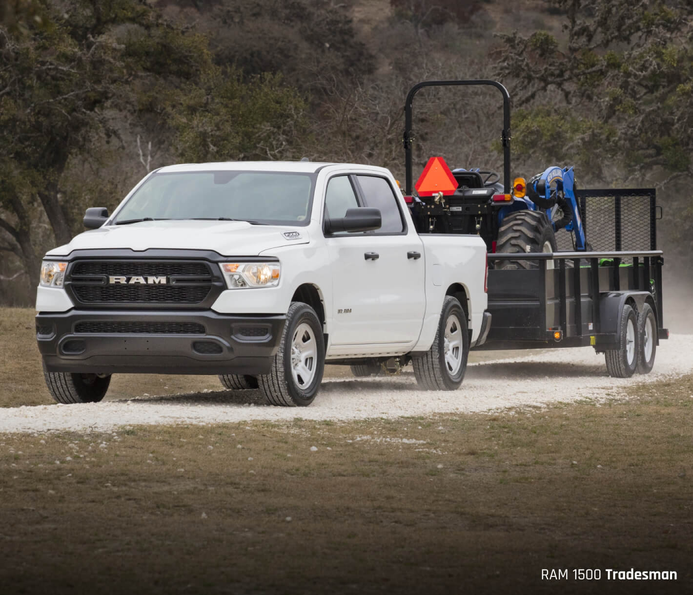 White Ram 1500 towing a trailer with a tractor in it